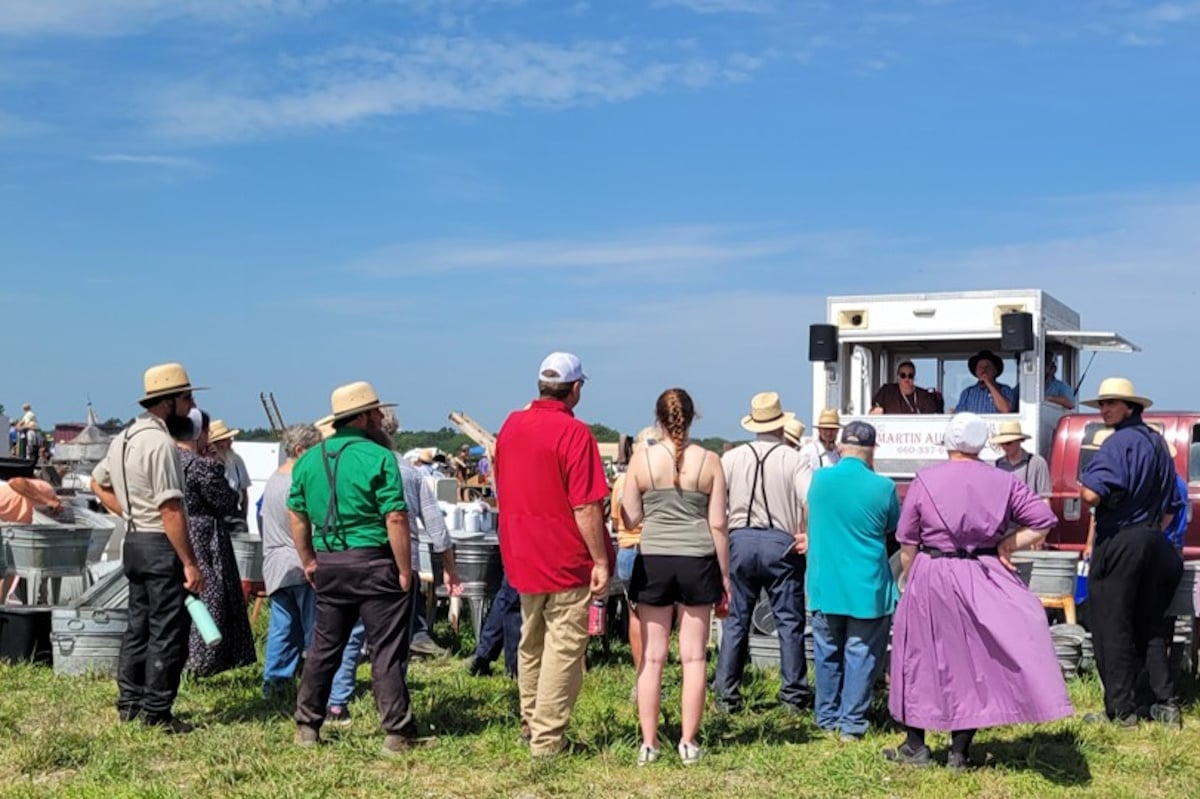 Amish and English buyers gathered around an auctioneer's truck at the Jamesport Amish School Auction
