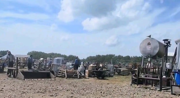 Rows of auction items spread across the dirt at the Jamesport Amish School Auction