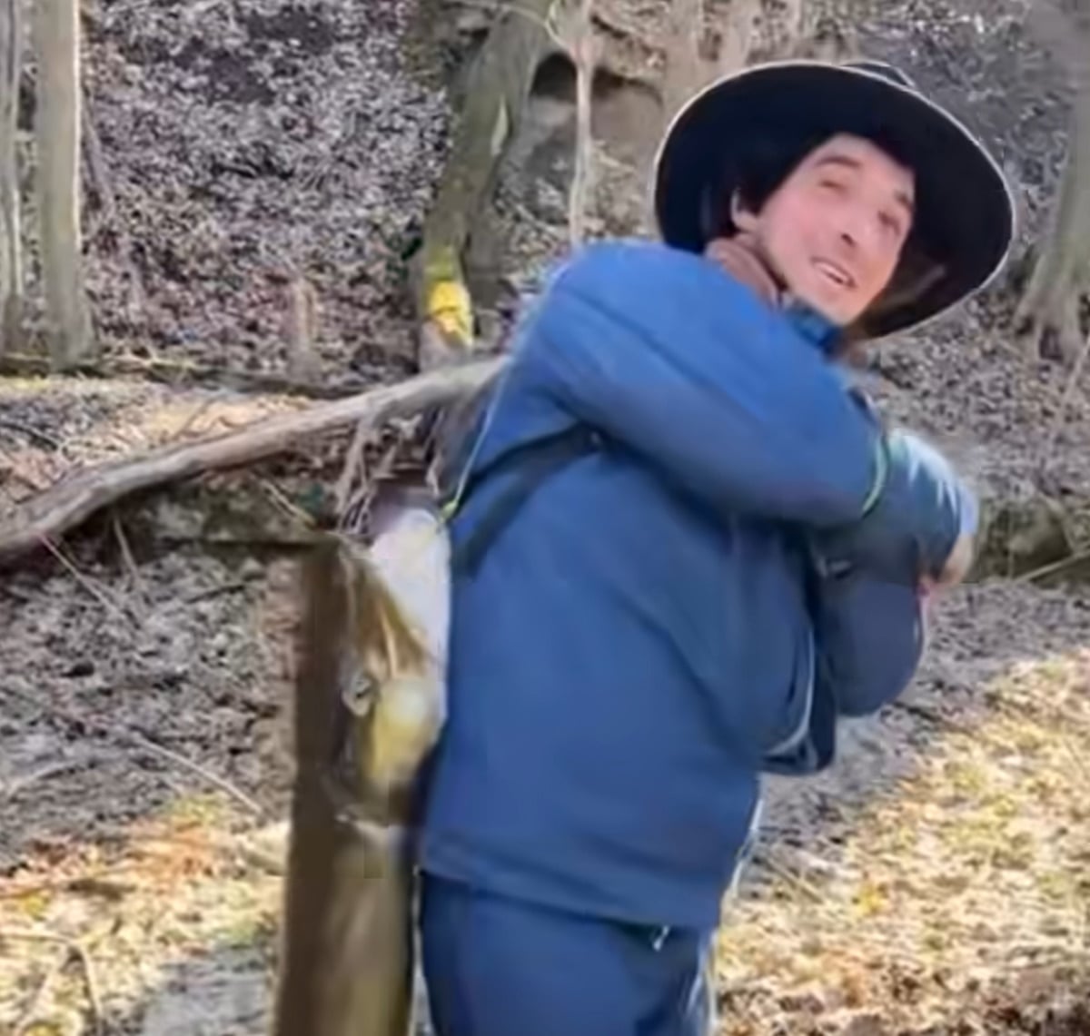 Amish man smiling carrying giant fish