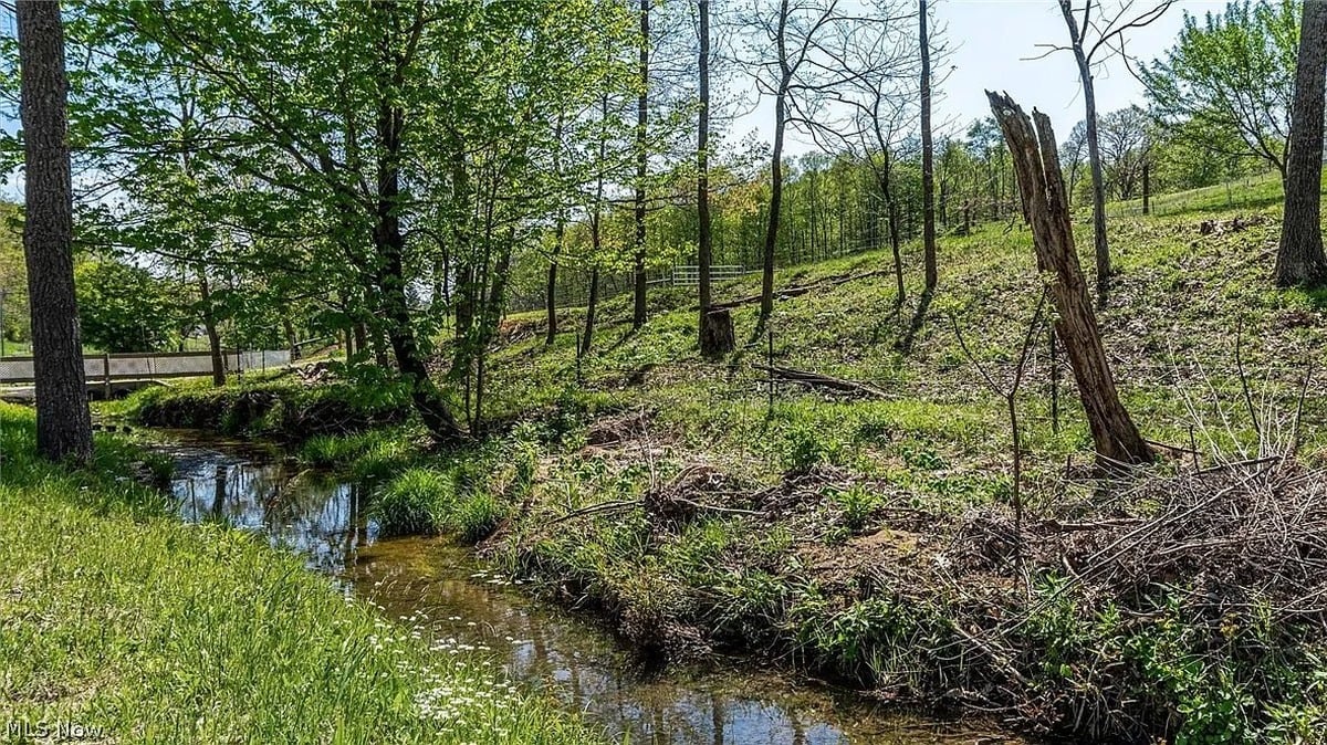 Creek running through wooded area of Amish homestead property in Cumberland Ohio with wooden footbridge
