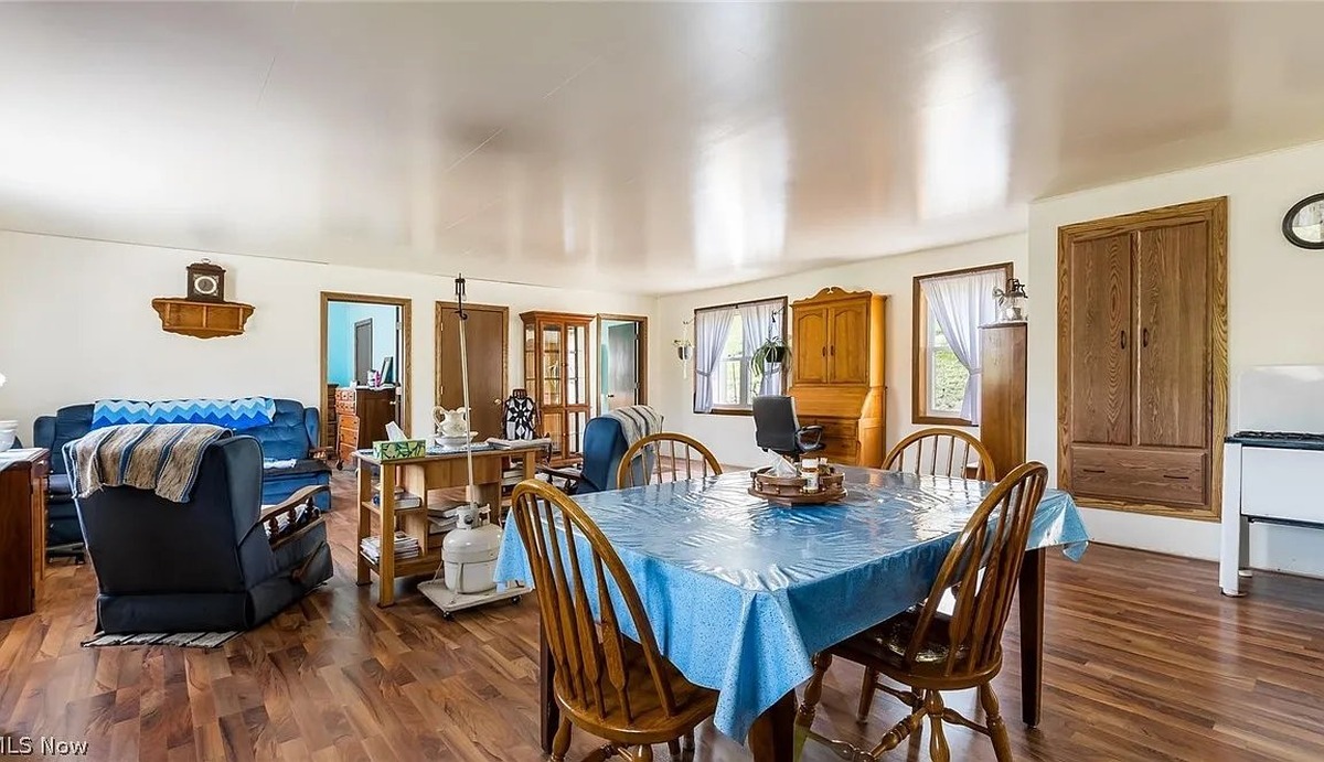 Open living and dining room in Amish home in Cumberland Ohio with wood floors and wooden furniture