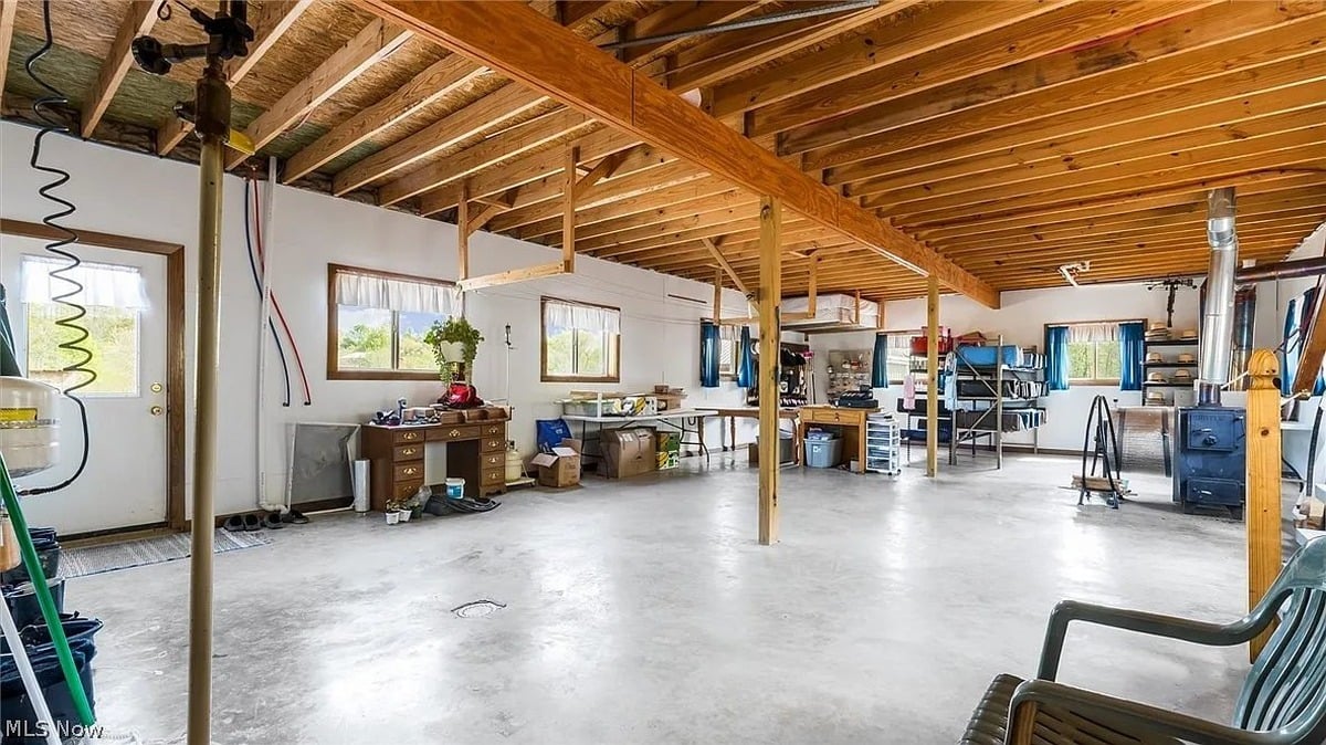 Lower level workshop interior of Amish home Cumberland Ohio showing wood stove and staircase