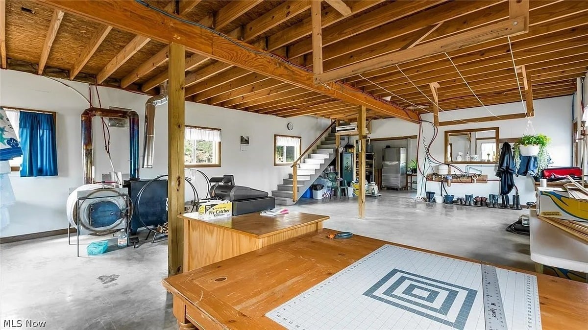 Ground floor workshop of Amish metal building home in Cumberland Ohio with wood stove and exposed beams