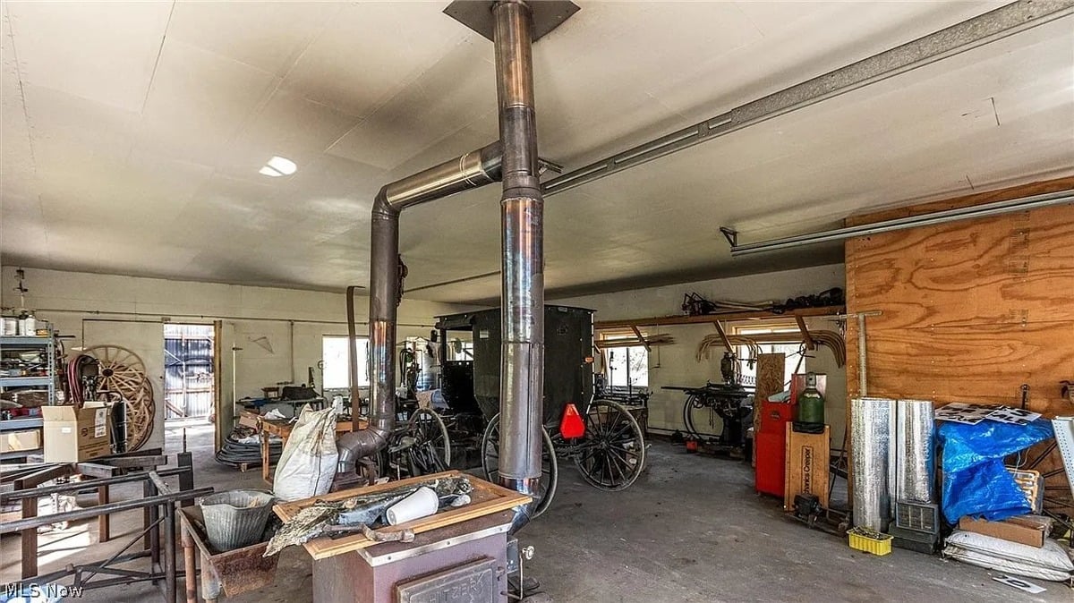 Interior of large outbuilding at Amish homestead Cumberland Ohio with Amish carriages and wood stove