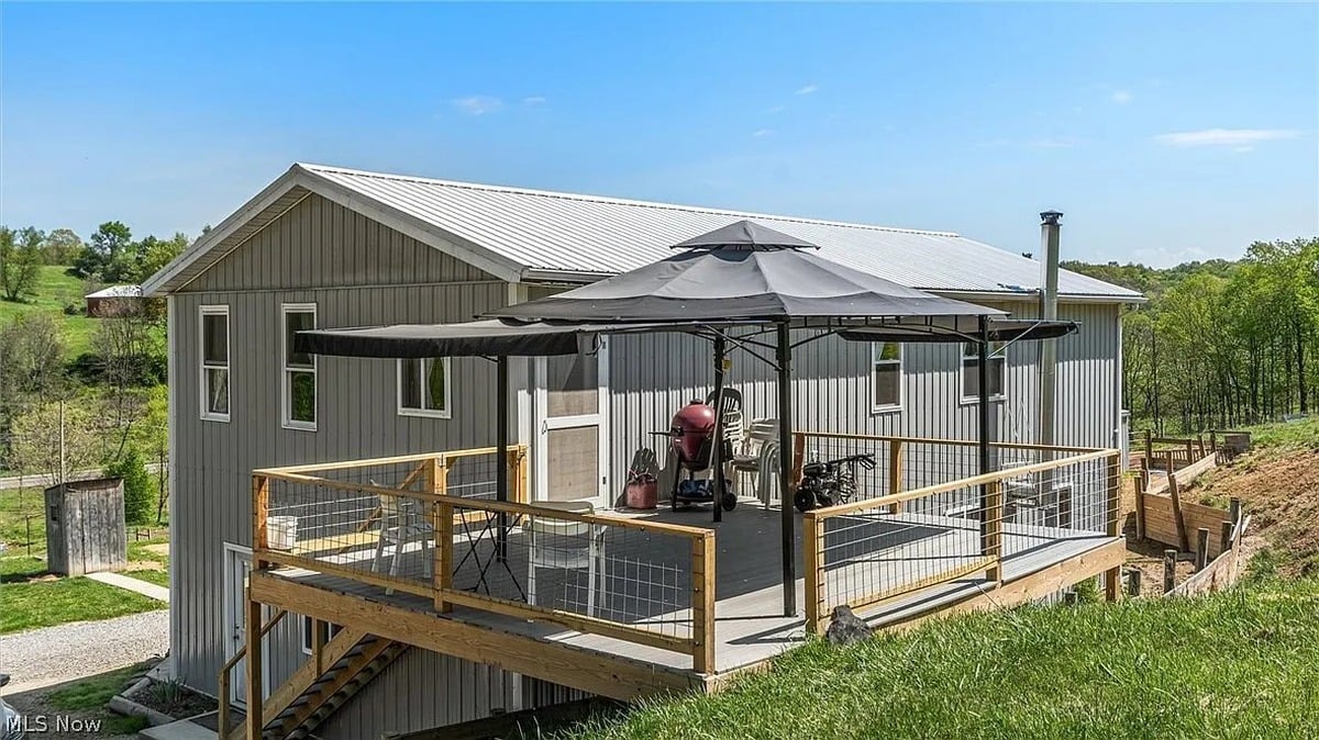 Rear deck of Amish-built metal building home in Cumberland Ohio with gazebo and rolling hill views