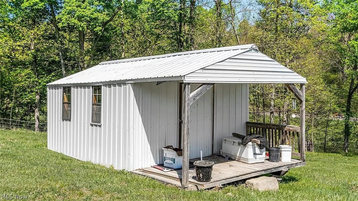 Small white metal shed with covered porch at Amish homestead Cumberland Ohio