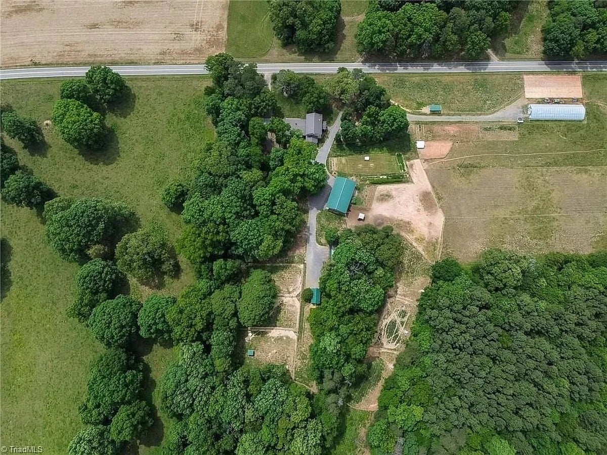 High aerial view of Amish property in Hamptonville, North Carolina showing home, barn, outbuildings, and surrounding acreage