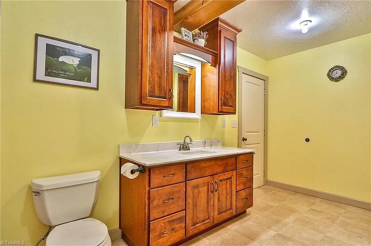 Bathroom with large custom wood vanity and upper cabinets in Amish home, Hamptonville, NC with yellow-green walls