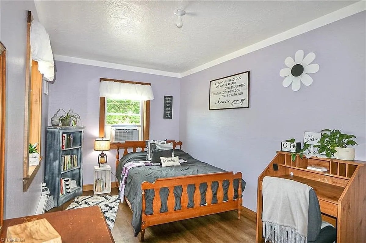 Children's bedroom in Amish home, Hamptonville, NC with lavender walls, wooden bed, and Be Strong and Courageous scripture sign