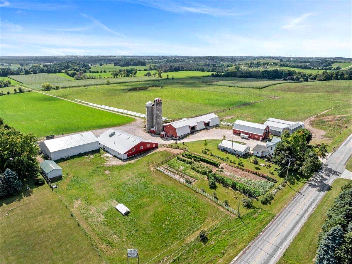Aerial view of Amish organic dairy farm in New Holstein, Wisconsin with red barns, silos, and garden