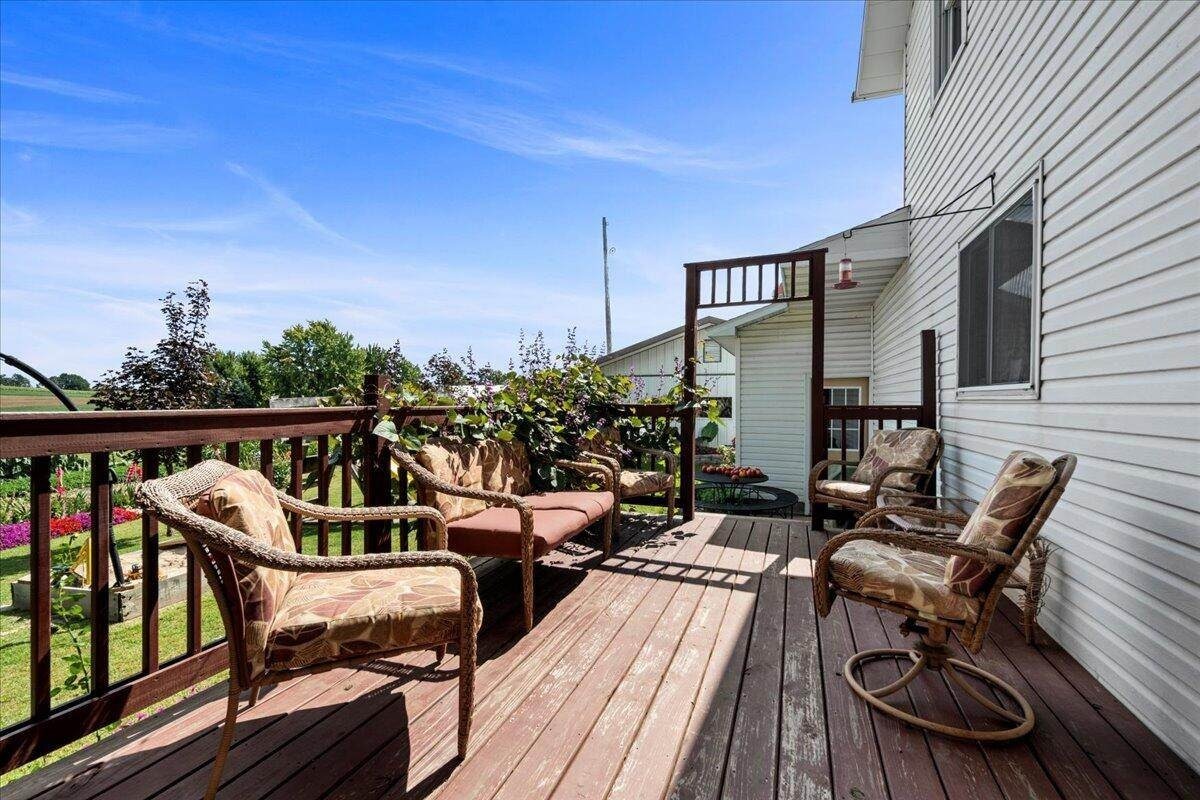 Back deck with wicker furniture overlooking garden at Amish farmhouse, New Holstein, Wisconsin
