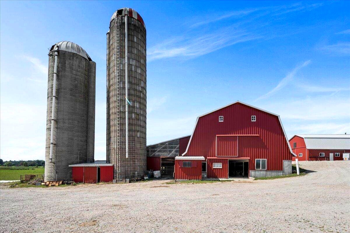Two concrete silos and red dairy barn exterior at Amish organic farm in New Holstein, Wisconsin