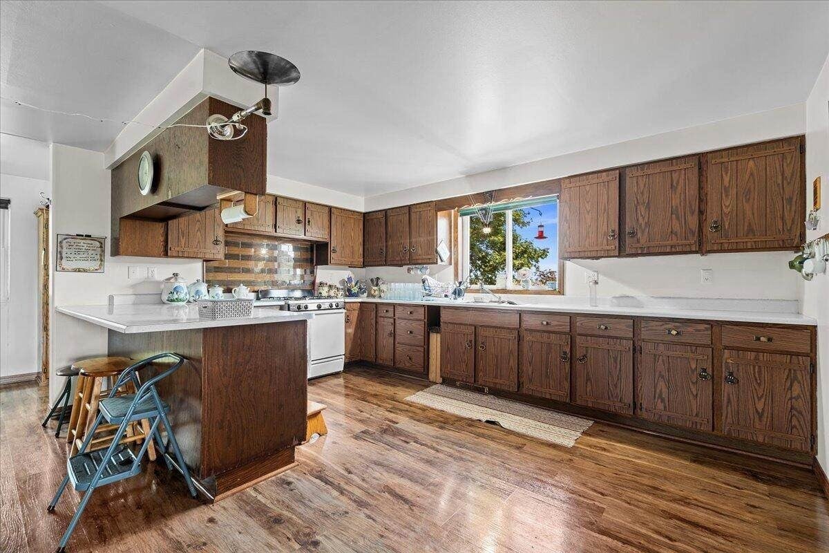 Wide view of kitchen with dark wood cabinets and peninsula in Amish farmhouse, New Holstein, Wisconsin
