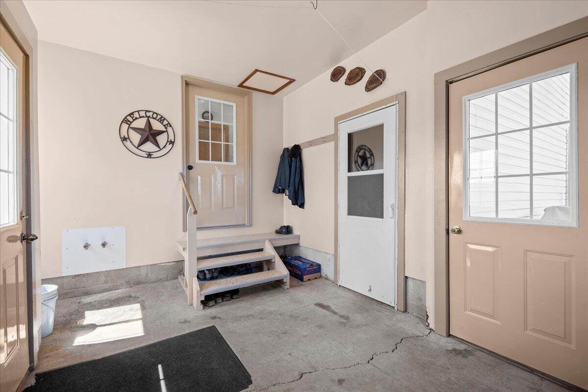 Mudroom entry with concrete floor and coat hooks in Amish farmhouse, New Holstein, Wisconsin