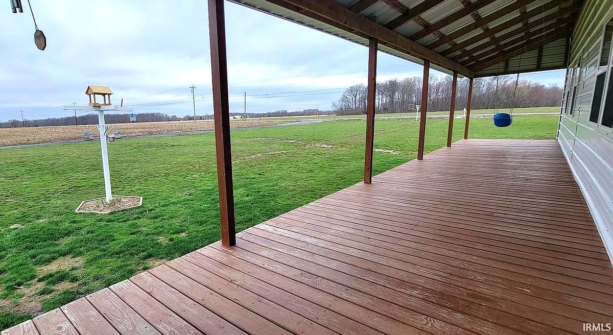 Covered porch of Amish home in Vevay, Indiana looking out over grassy yard with birdfeeder