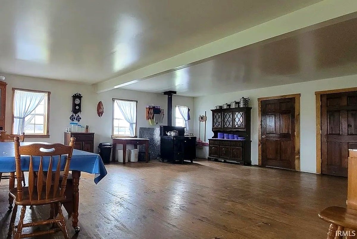 Main room of Amish home in Vevay, Indiana showing wood stove, china cabinet, and hardwood floors