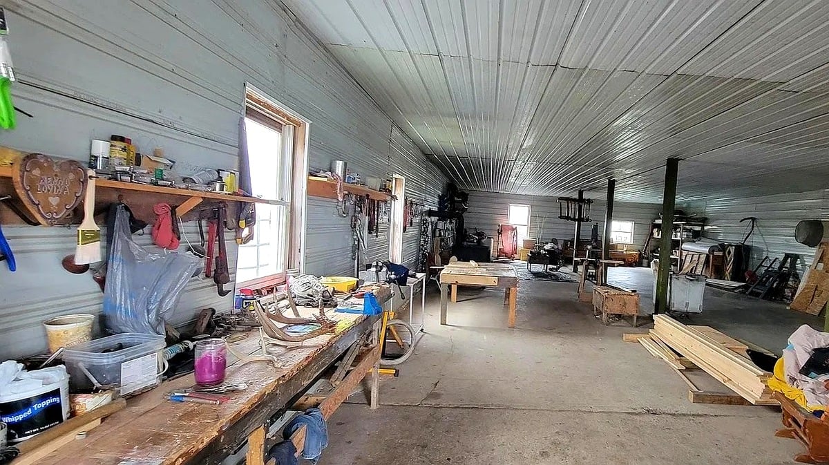Workshop interior with long workbench, tools, and lumber at Amish farm in Vevay, Indiana