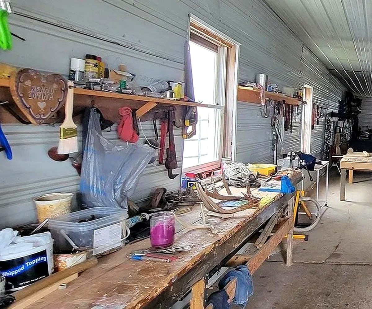 Workbench closeup with tools and carved wooden heart sign at Amish farm workshop in Vevay, Indiana