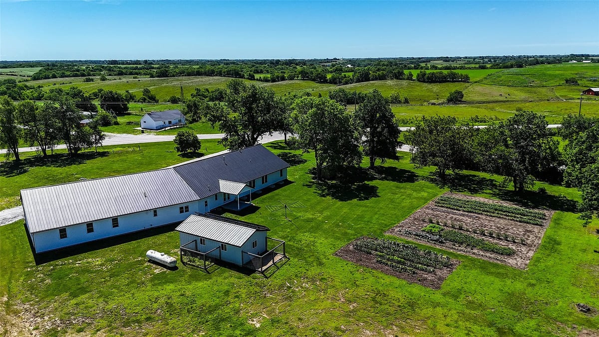 Aerial of the Winterset Amish homestead and garden plots Aerial view of Amish homestead in Winterset Iowa with home, small outbuilding, and garden plots