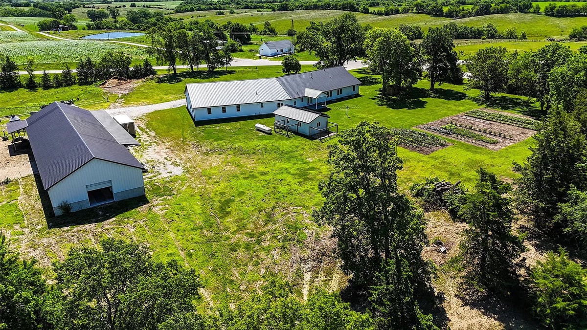 Aerial of the Winterset Amish homestead and outbuildings Aerial of Amish homestead in Winterset Iowa showing home, outbuildings, and garden plots