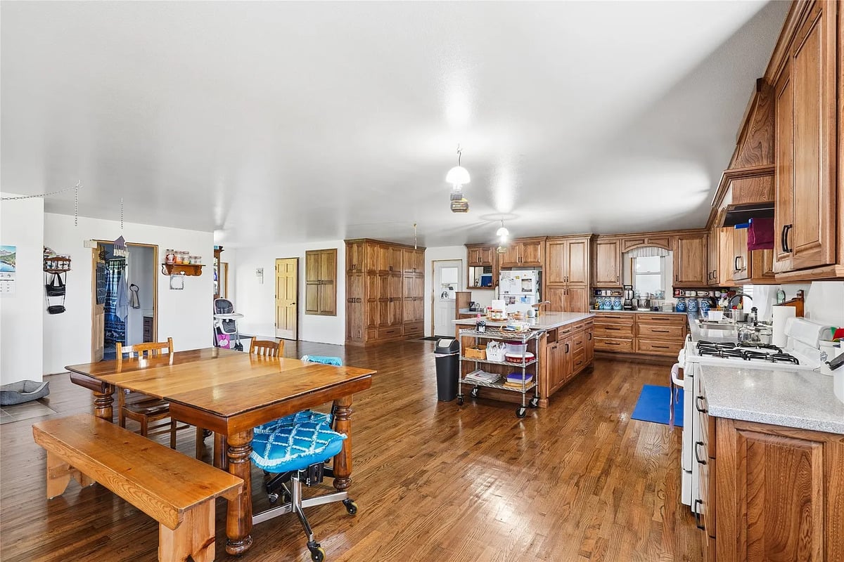 Open great room with kitchen and dining area in the Winterset Amish home Open-plan Amish kitchen and dining great room with hardwood floors and oak cabinetry