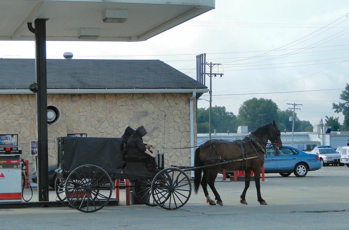 Two Amish women in an open buggy at a gas station in Lawrence County, Indiana