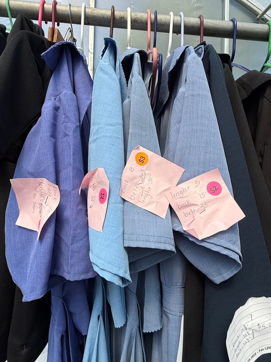 Men's Amish shirts and trousers on hangers with handwritten price tags