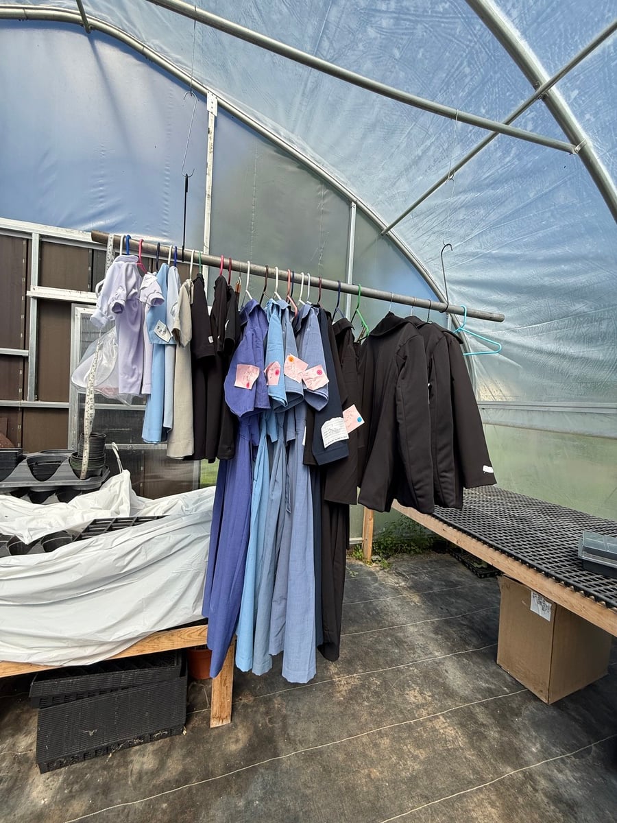 Racks of secondhand Amish clothing hanging inside a greenhouse in Cass City, Michigan