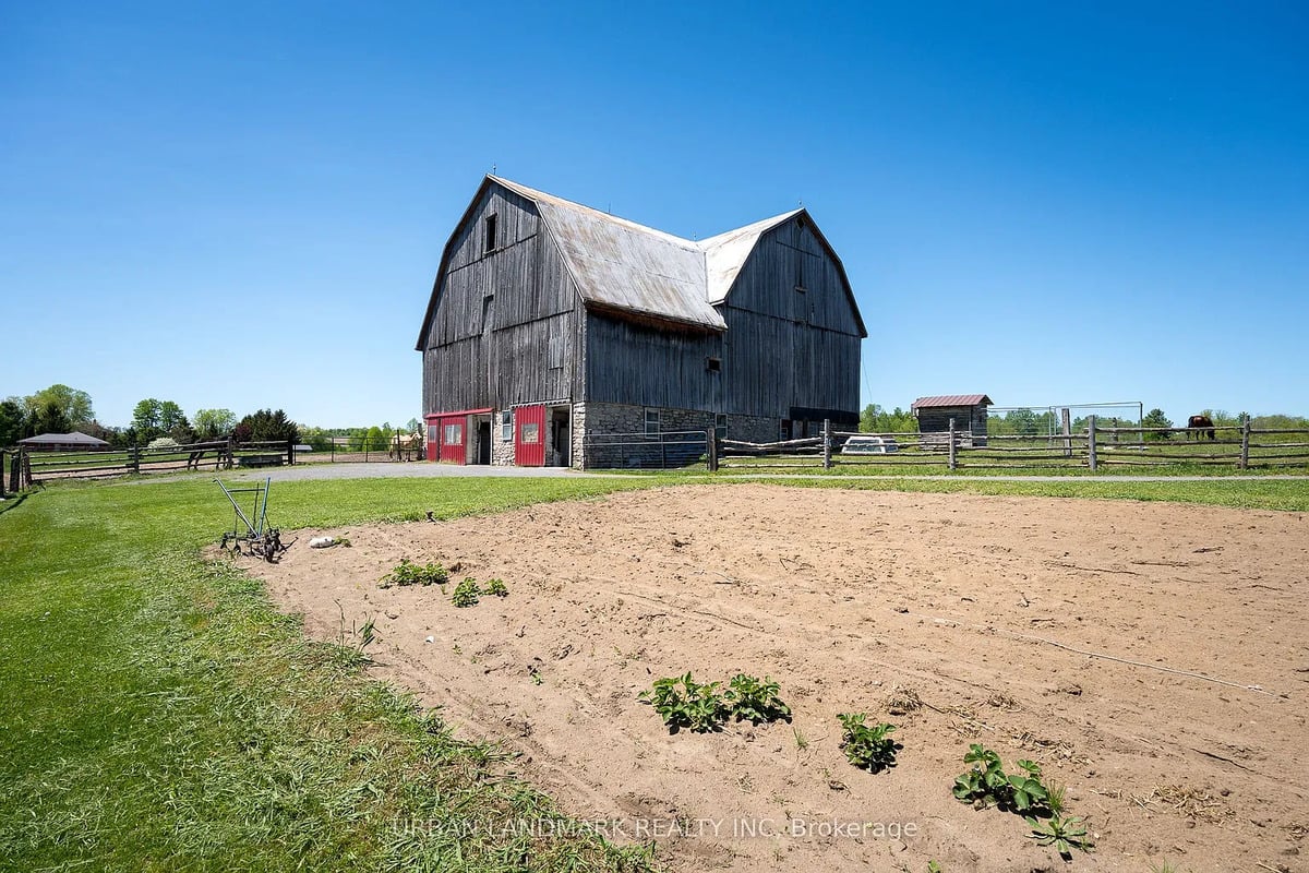 Garden and barn on an Amish farm in Ontario Garden plot with hand cultivator in front of a gambrel barn on an Amish farm in Ontario
