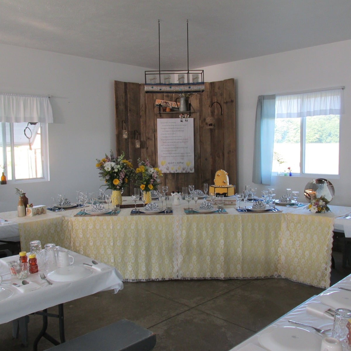 Bee-themed bridal corner at an Amish wedding with yellow lace tablecloth and beehive cake