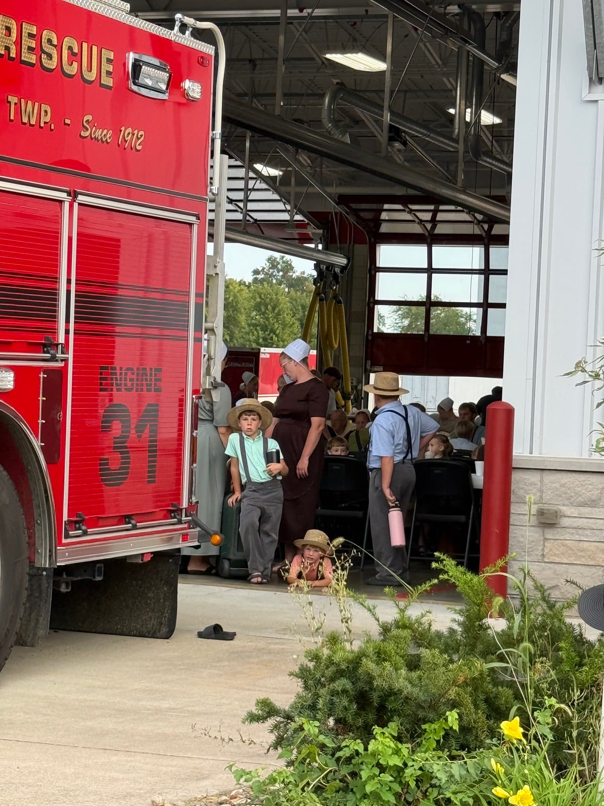 Amish boys in straw hats at the bay door next to Engine 31