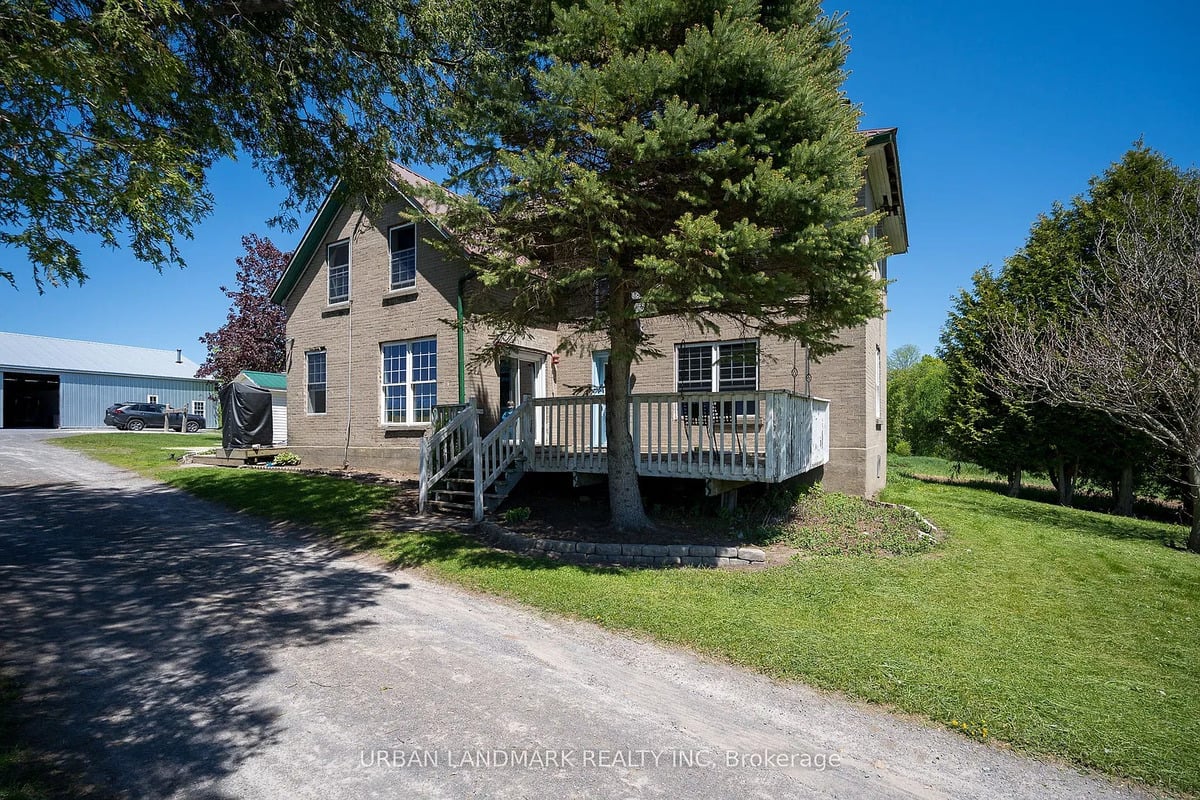 Brick Amish farmhouse near Stirling, Ontario Brick Amish farmhouse with wooden deck and spruce tree near Stirling, Ontario