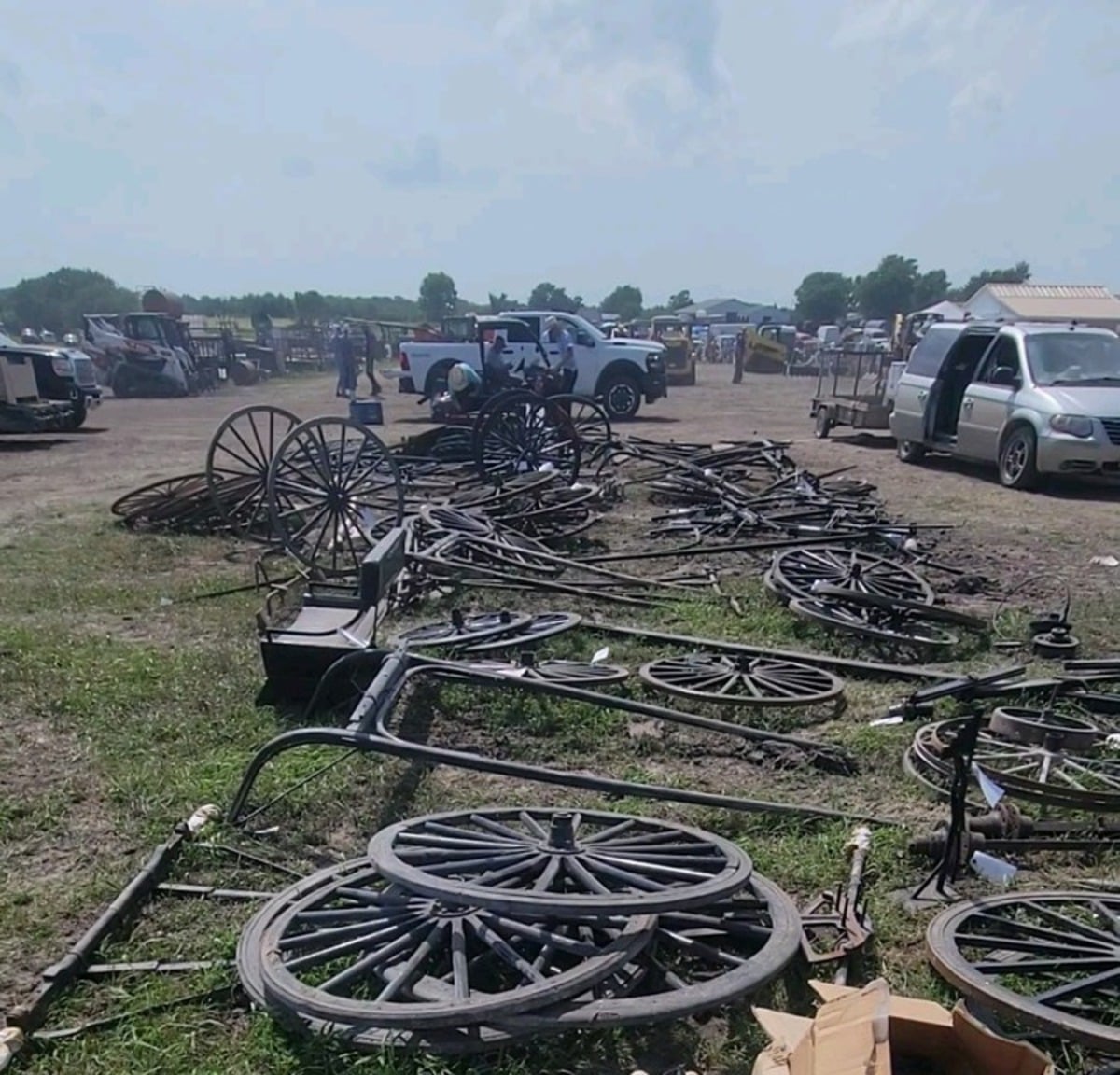 Buggy wheels, shafts and carriage parts spread across the auction grounds