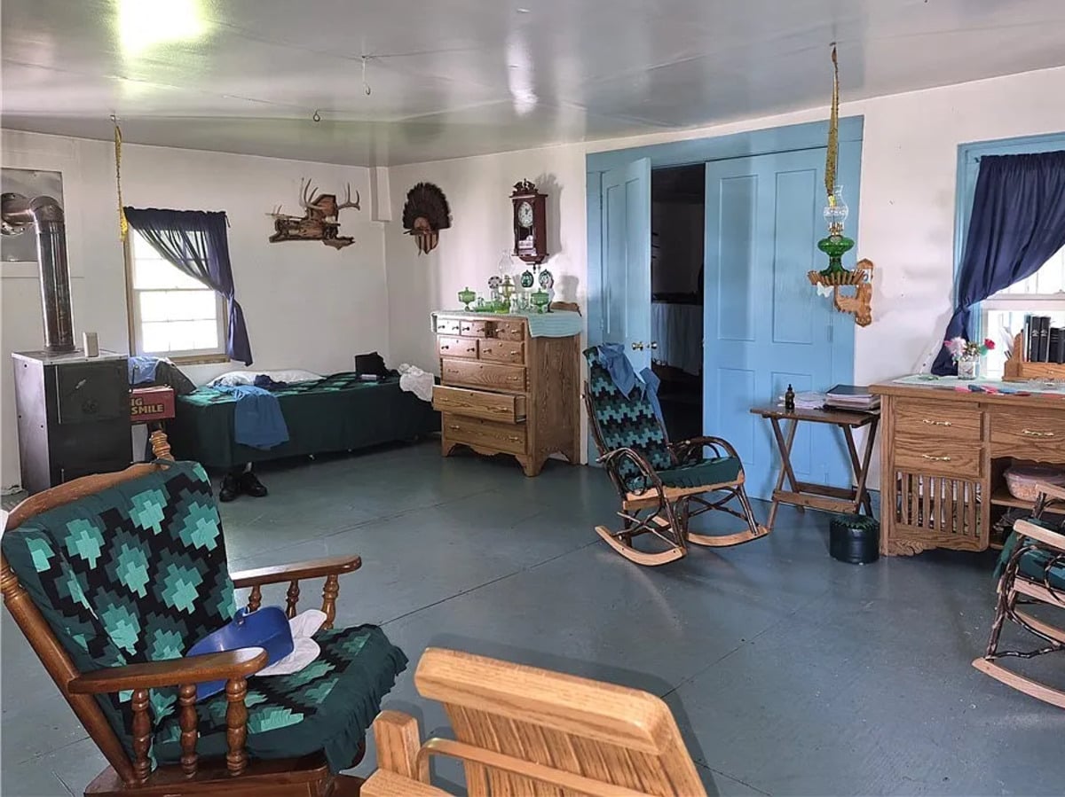 Open front room of a Conewango Valley, New York Amish home with blue doors, oil lamp, and quilted rocking chairs