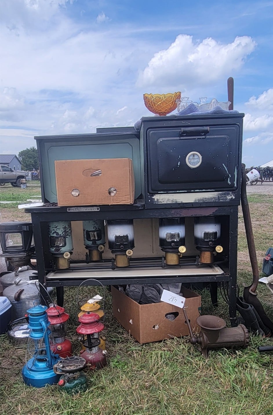 A cookstove with kerosene lanterns and household items at the Amish auction