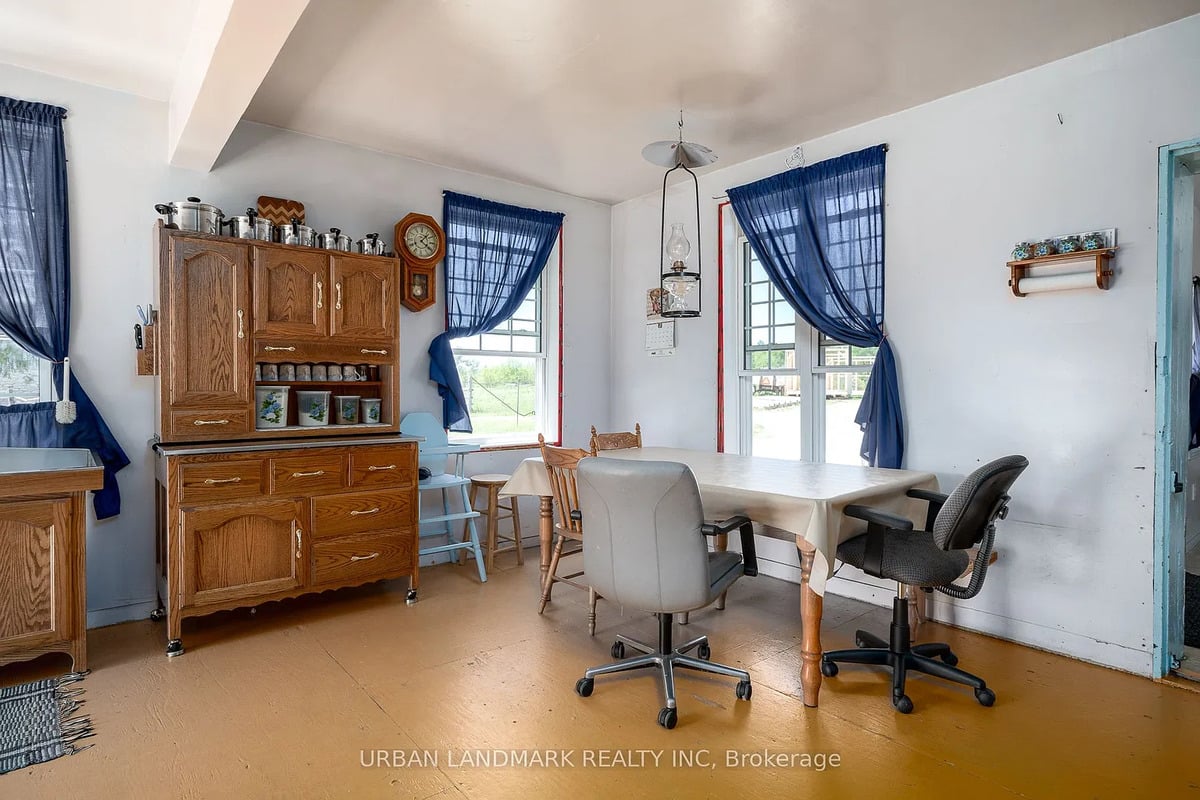 Kitchen table in an Amish home near Stirling, Ontario Amish kitchen table with office chairs, hanging lamp, oak cabinet and wall clock in Ontario