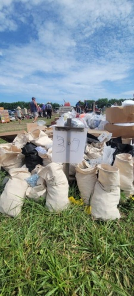 Canvas bags of small parts grouped behind a handwritten lot number sign