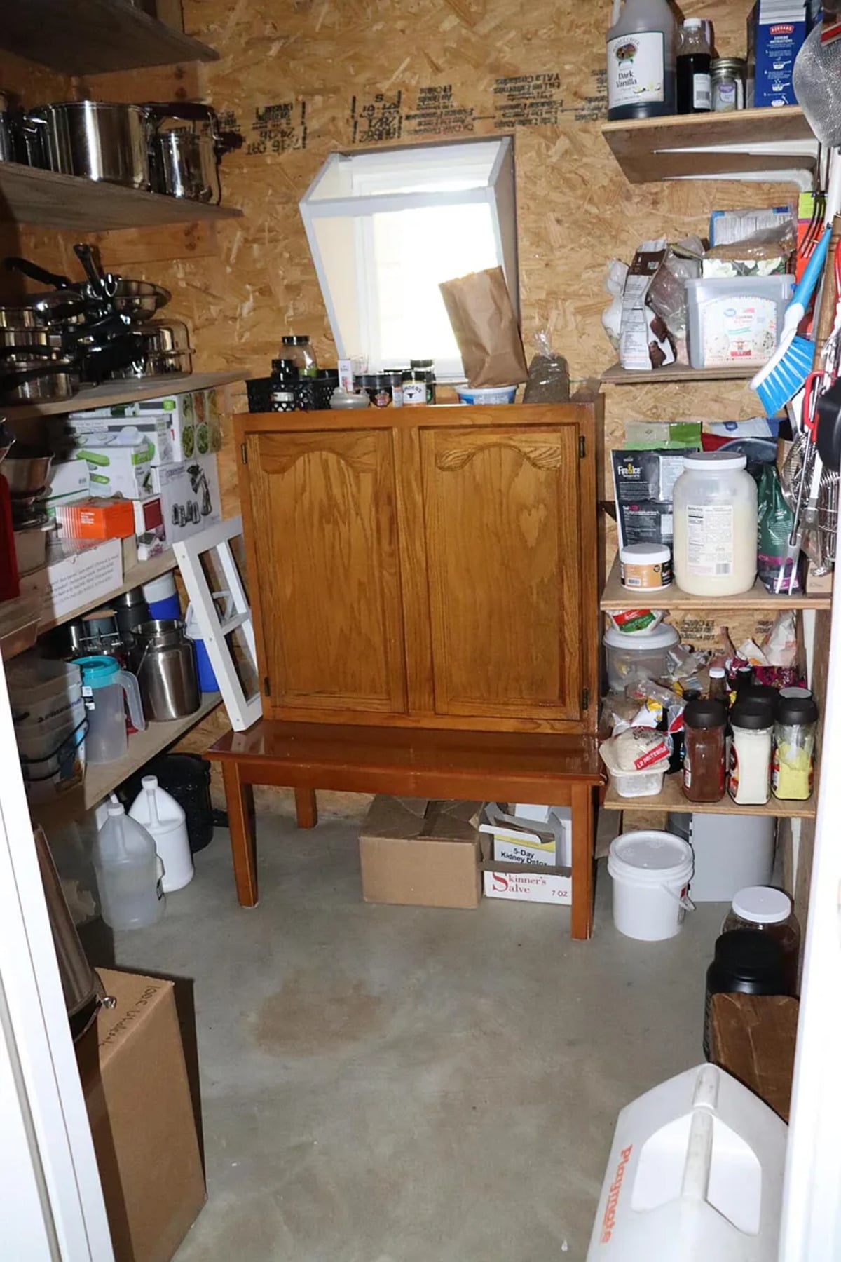 A corner of the Amish pantry with a cabinet on a bench and boxed goods on the floor