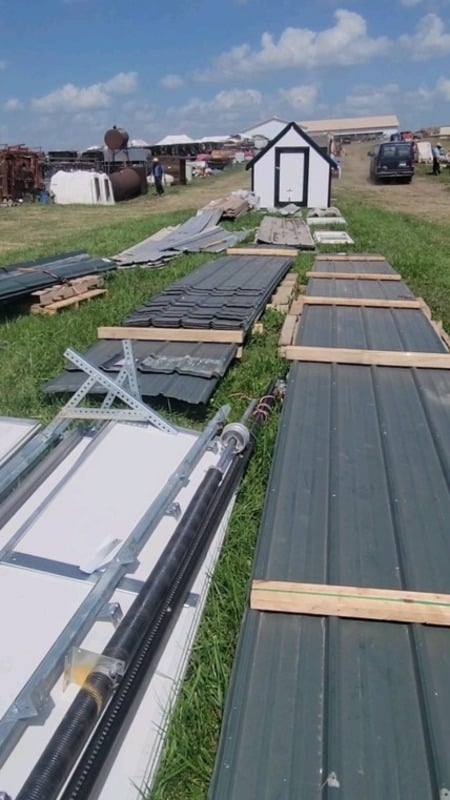Stacks of metal roofing and siding panels laid out on the auction grounds