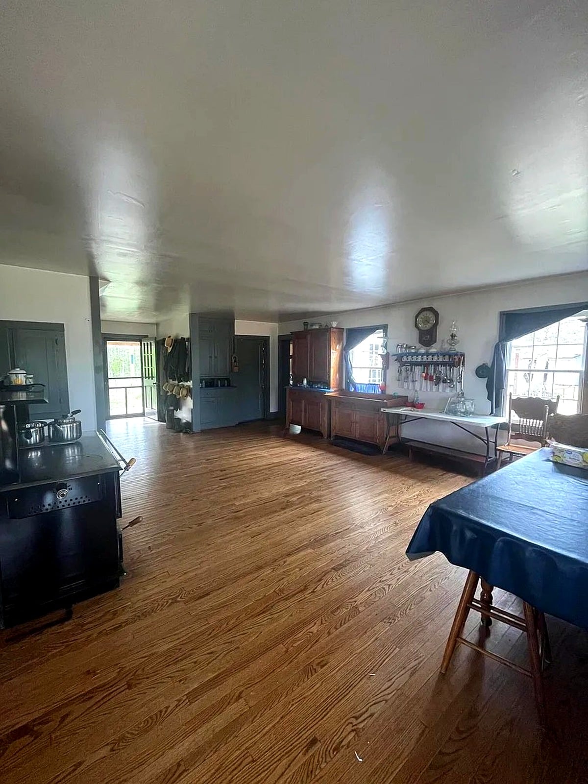 Kitchen and main room of Amish home in Mississippi with wood cookstove and dining table