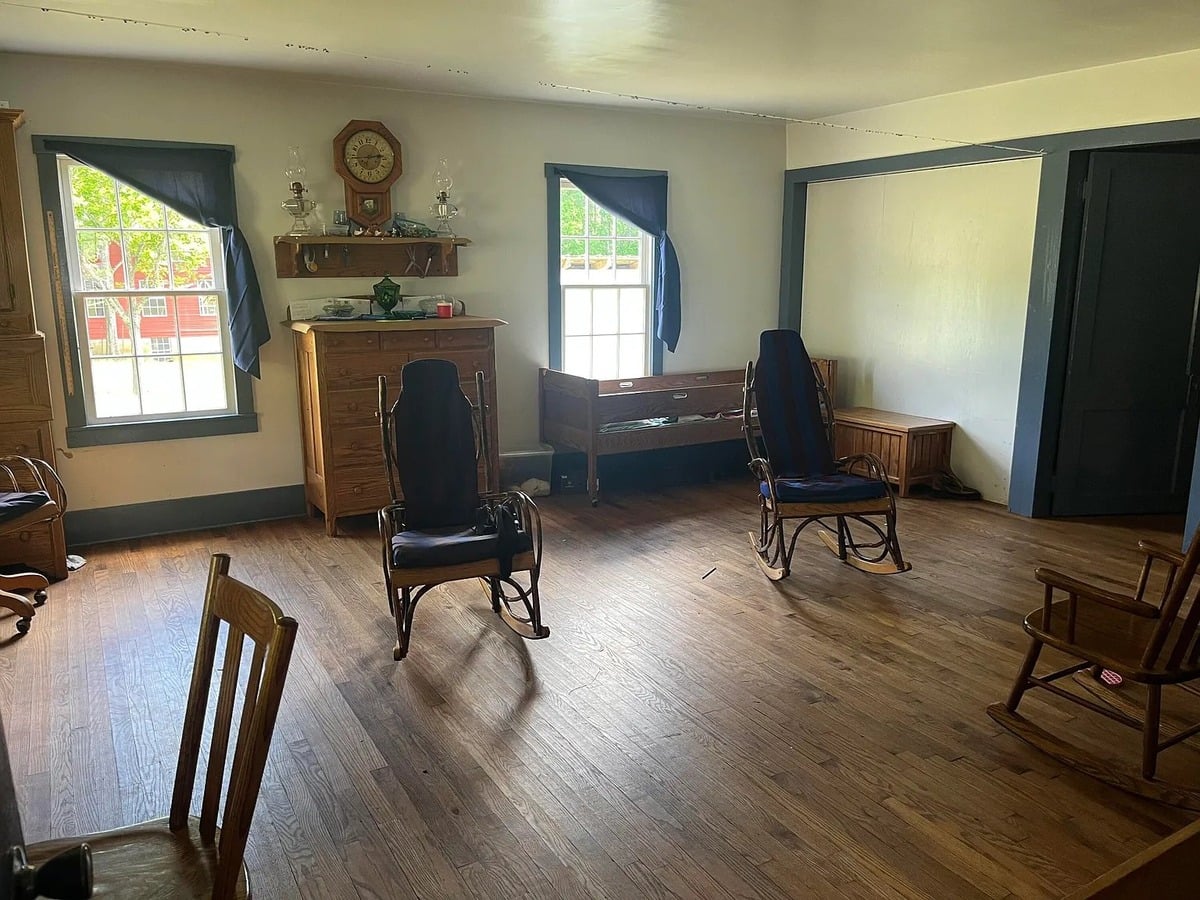 Amish living room with hickory rockers, wall clock, oil lamps, dresser, and hardwood floors, Randolph Mississippi
