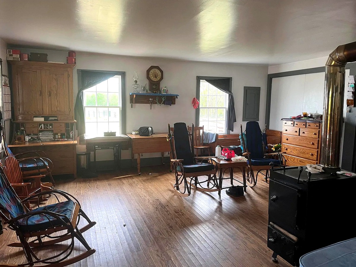 Living room of a Swartzentruber Amish home in Mississippi with hickory rockers, sewing machine, and wood stove