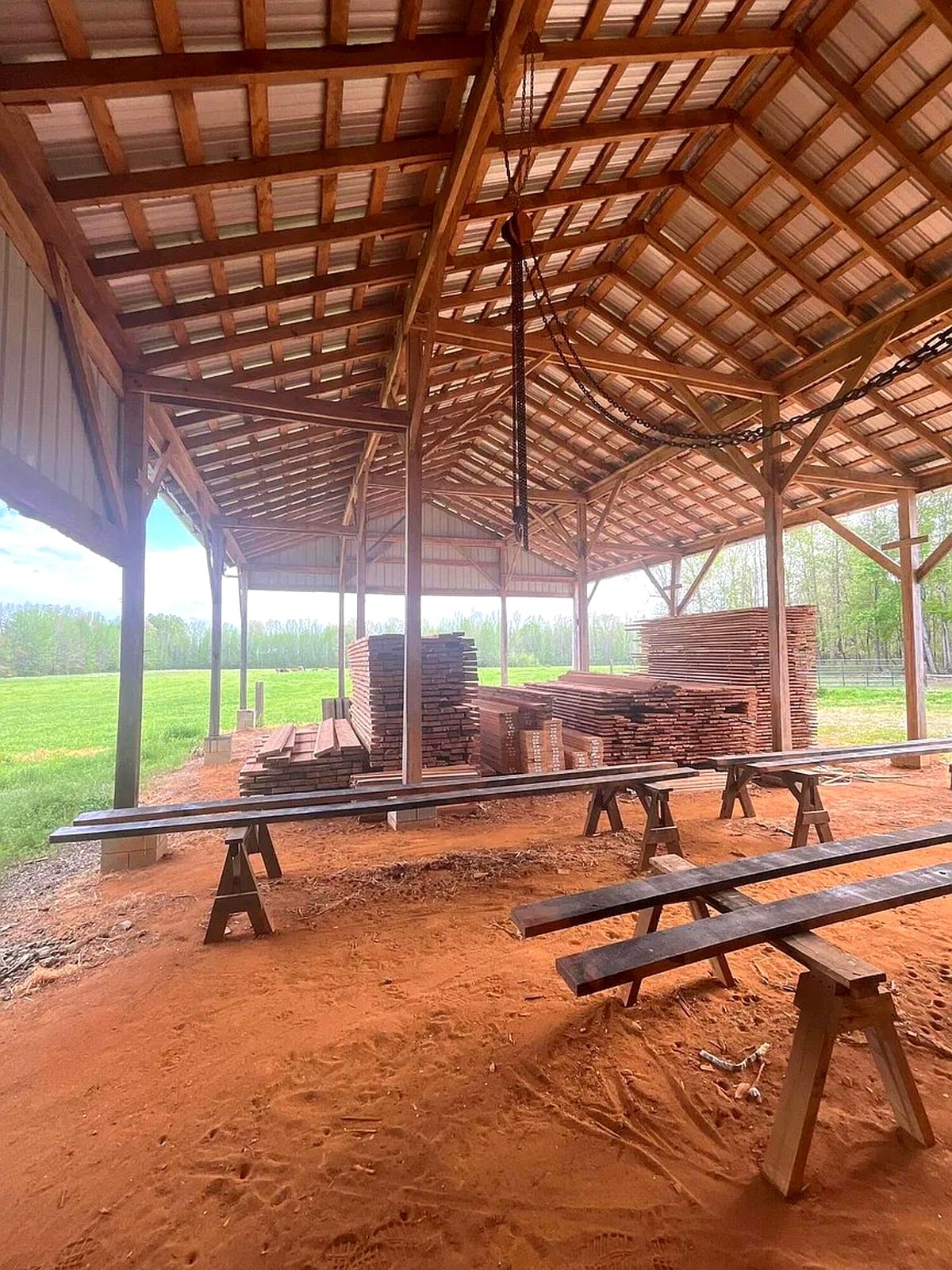 Lumber drying shed with stacked boards and sawhorses at an Amish property in Mississippi