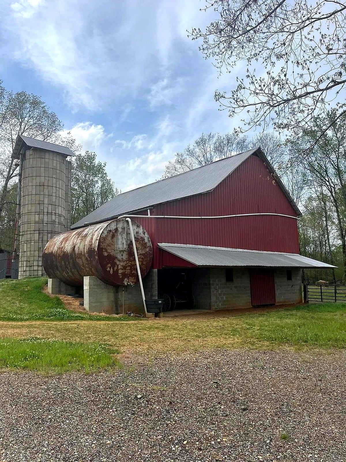 Red barn with grain silo and large water tank at Amish farm in Pontotoc County, Mississippi