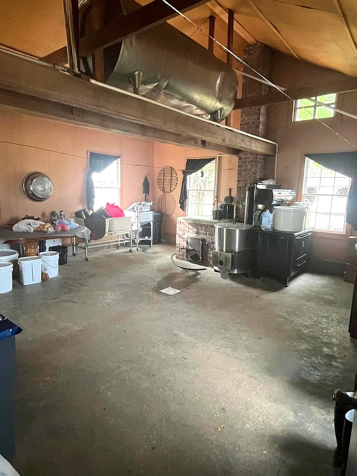 Summer kitchen or utility room inside Amish home in Mississippi with brick cookstove and concrete floor