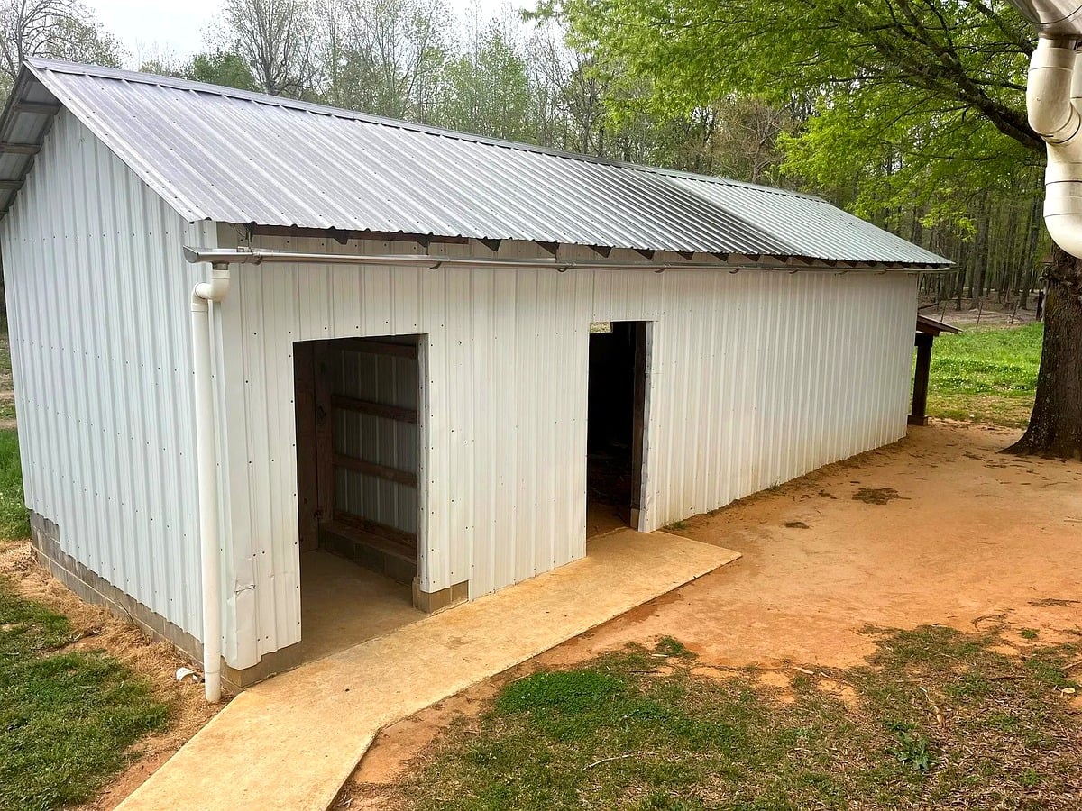 White metal outbuilding with open doors at an Amish property in Mississippi