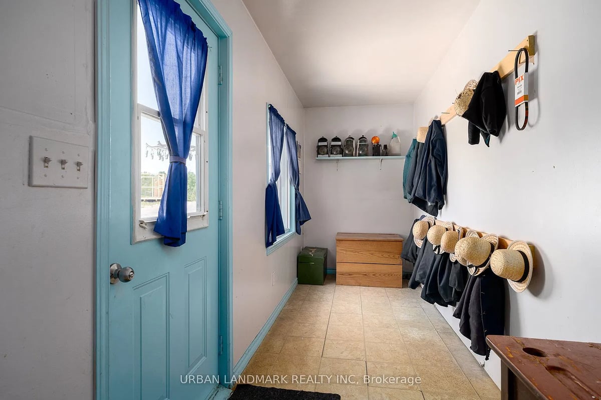 Mudroom in an Amish home near Stirling, Ontario Mudroom with straw hats, black coats, buggy lanterns and a light switch in an Amish home near Stirling, Ontario