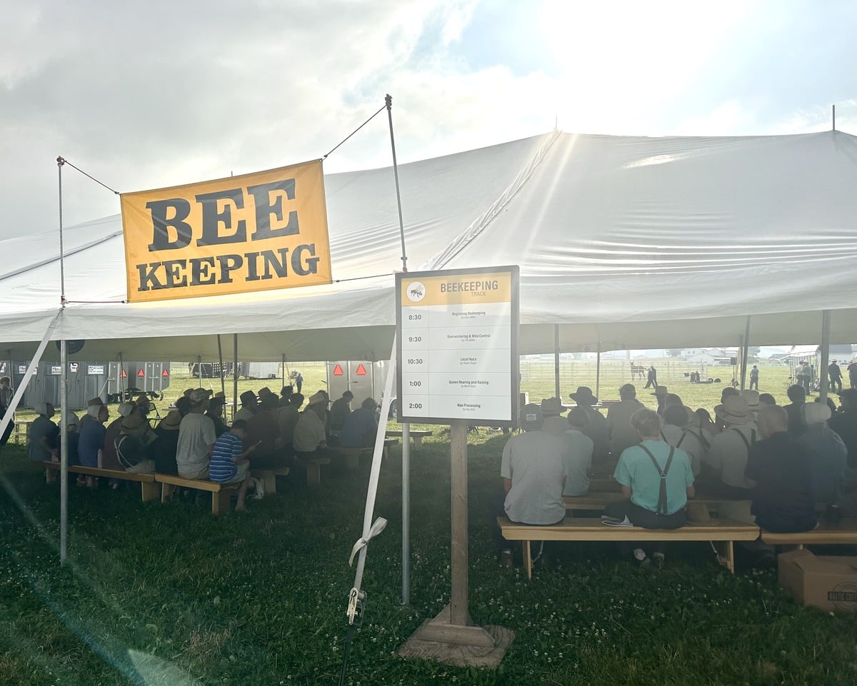 The beekeeping tent and schedule board at the Amish Family Farm Field Days