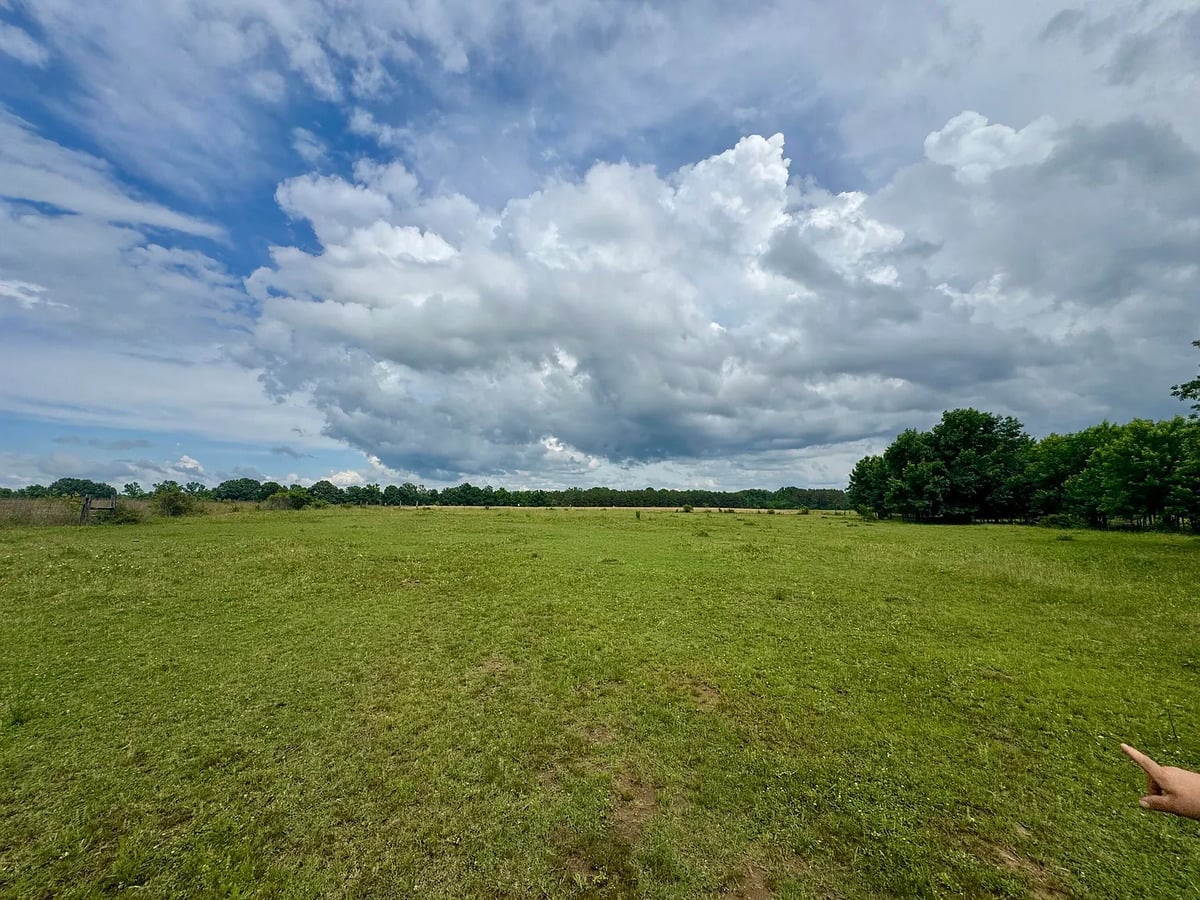 Open green pasture under storm clouds on an Amish farm in Randolph, Mississippi
