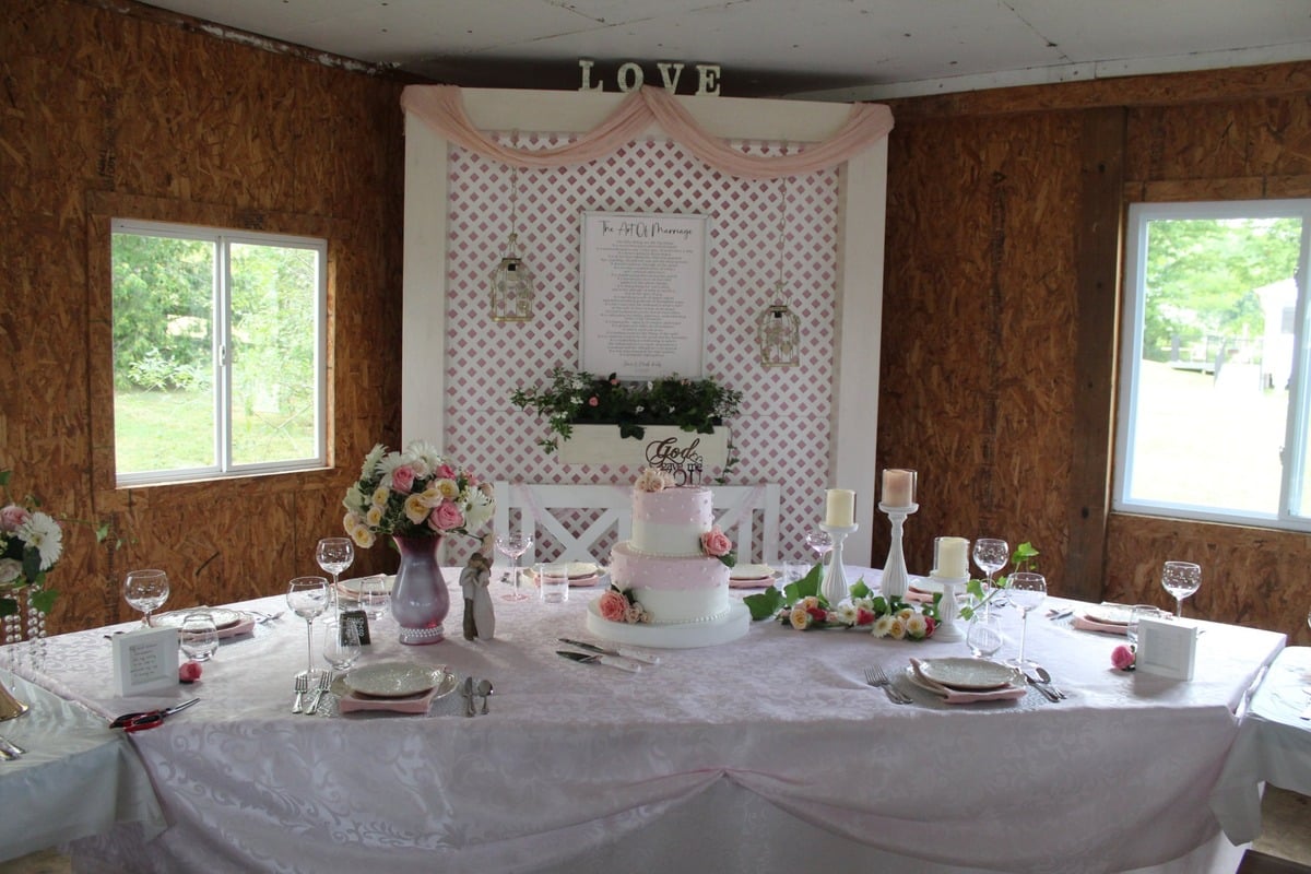 Pink bridal corner at an Amish wedding with lattice backdrop and LOVE sign
